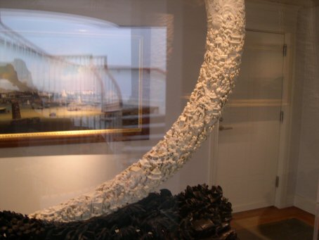 An enormous tusk carved over the entire surface with 3-D embodiment of village life